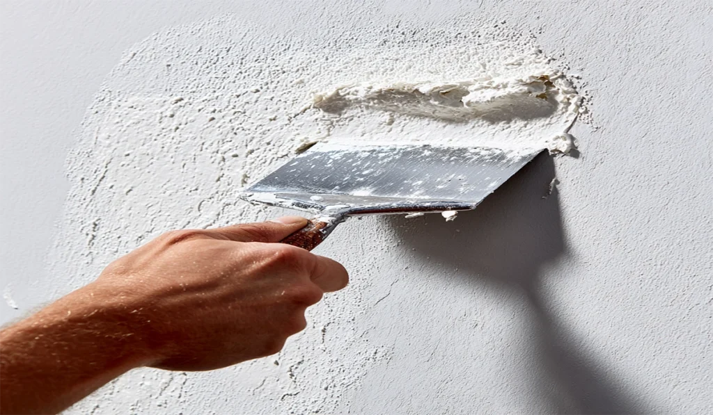 Wall Putty Powder: The Four Types, and How to Choose 1 Wall putty powder applied in a thin coat with a spatula
